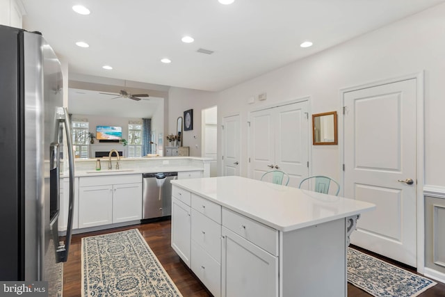 kitchen with sink, appliances with stainless steel finishes, a kitchen breakfast bar, a center island, and kitchen peninsula