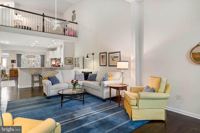 living room featuring an inviting chandelier, dark hardwood / wood-style floors, and a high ceiling