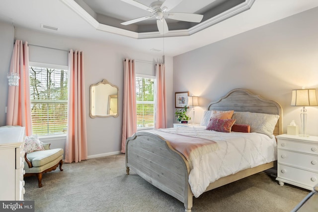 bedroom featuring ceiling fan, a raised ceiling, and light carpet