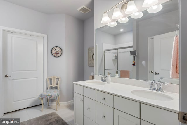 bathroom with tile patterned floors, vanity, and a shower with door