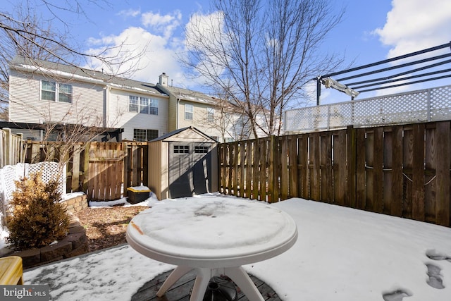 yard covered in snow with a storage shed