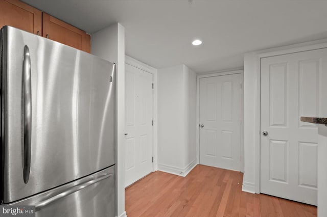 kitchen with light wood-type flooring and stainless steel refrigerator