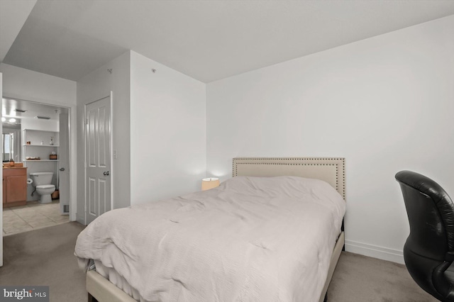 carpeted bedroom featuring ensuite bathroom