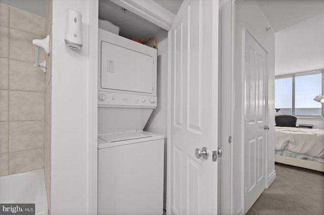 clothes washing area featuring stacked washer and dryer