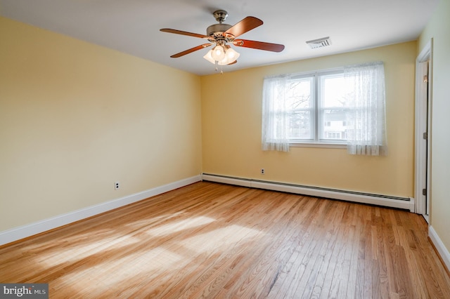 empty room with baseboard heating, ceiling fan, and light hardwood / wood-style floors