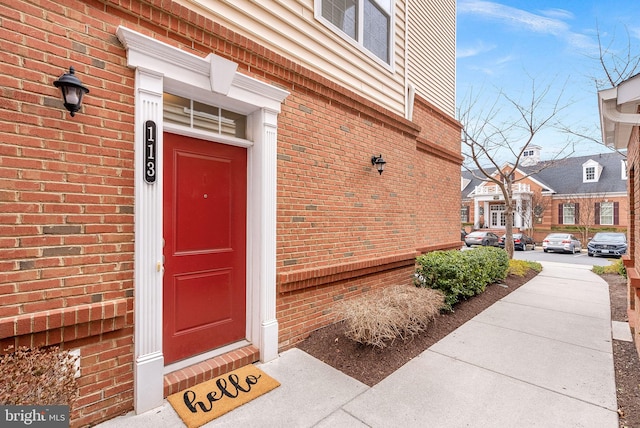 doorway to property featuring brick siding