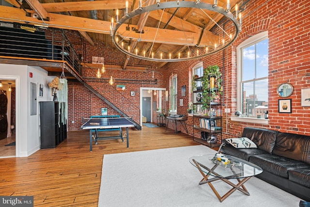 living room with a towering ceiling and brick wall