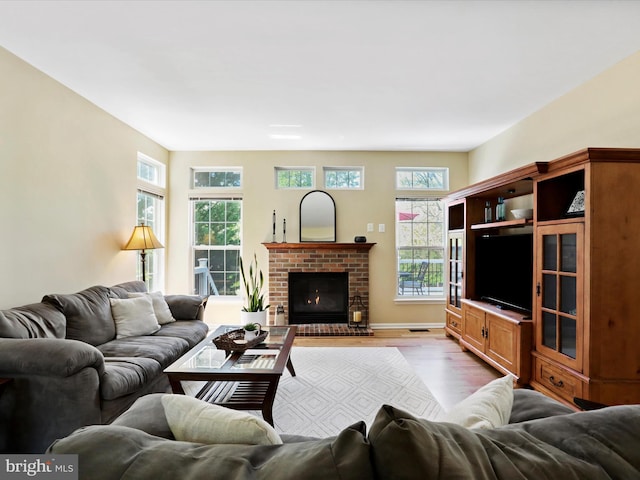 6852 Fielding Ct, Frederick, MD 21703 - living room featuring a brick fireplace and wood finished floors
