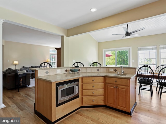 6852 Fielding Ct, Frederick, MD 21703 - kitchen featuring a healthy amount of sunlight, open floor plan, stainless steel microwave, light stone counters, and a sink