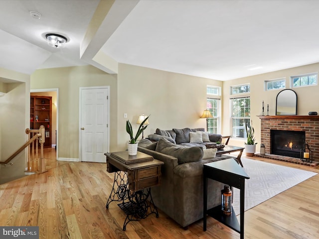 6852 Fielding Ct, Frederick, MD 21703 - living room with baseboards, a brick fireplace, and light wood-style flooring