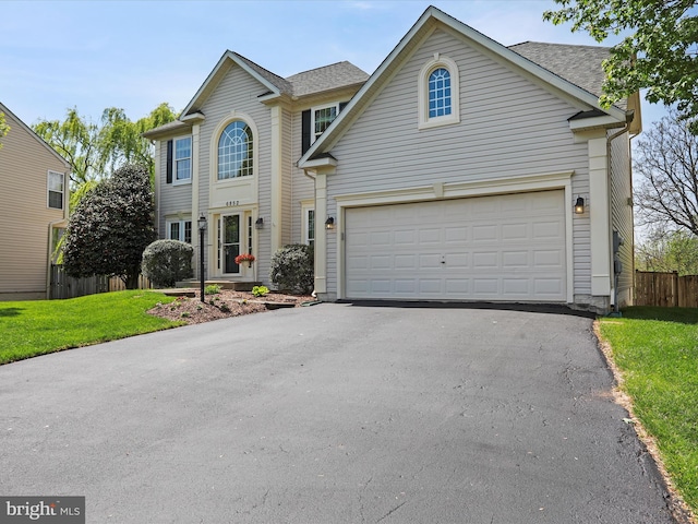 6852 Fielding Ct, Frederick, MD 21703 - view of front of house with fence, roof with shingles, a front lawn, a garage, and driveway