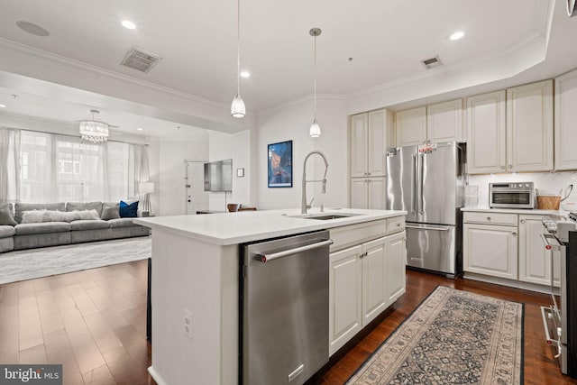 kitchen with sink, a center island with sink, dark hardwood / wood-style floors, pendant lighting, and stainless steel appliances