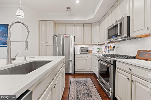 kitchen with white cabinetry, appliances with stainless steel finishes, sink, and decorative light fixtures