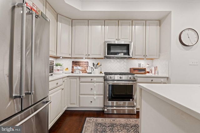 kitchen with white cabinetry, appliances with stainless steel finishes, dark hardwood / wood-style floors, and backsplash