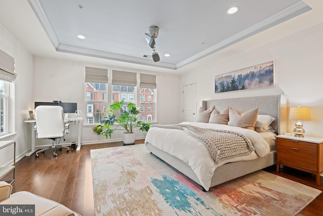 bedroom featuring a raised ceiling, crown molding, and dark wood-type flooring