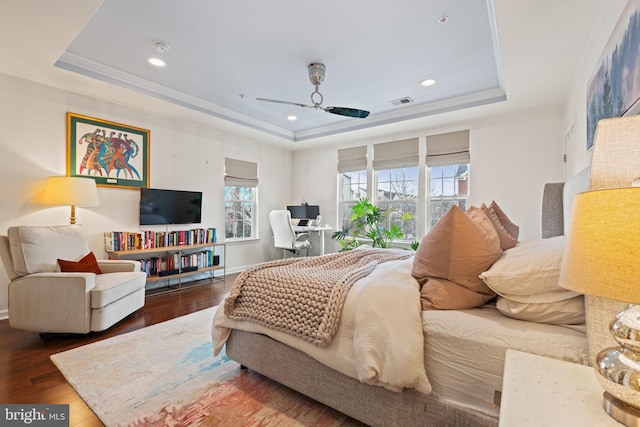 bedroom with dark hardwood / wood-style floors, a raised ceiling, and ceiling fan