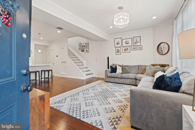 living room featuring ornamental molding, wood-type flooring, and a notable chandelier