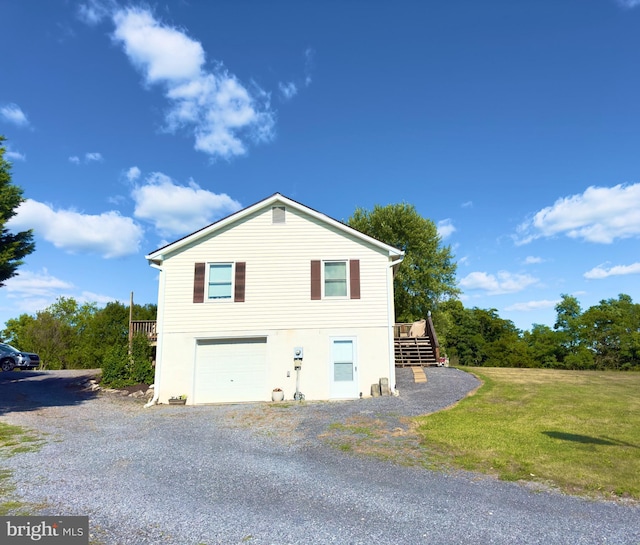 view of side of property with a yard, a garage, and a deck