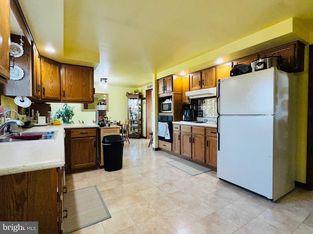 kitchen featuring tasteful backsplash, sink, and white appliances