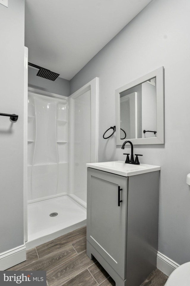 bathroom featuring walk in shower, vanity, and toilet