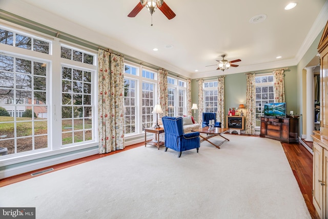 sunroom / solarium featuring a wealth of natural light, ceiling fan, and ornate columns