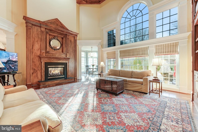 living room with a towering ceiling and wood-type flooring