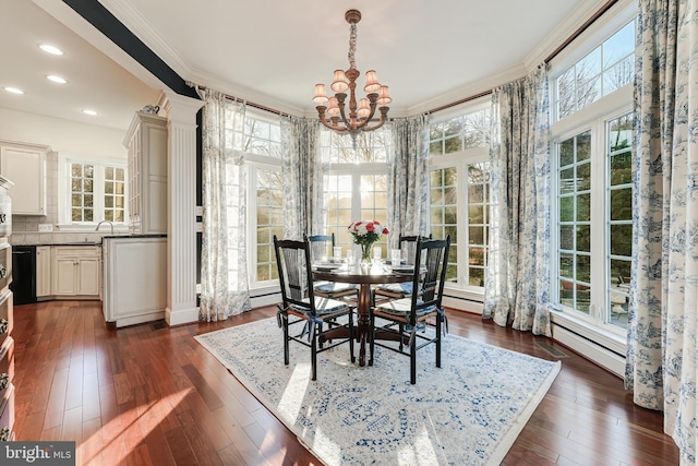 dining space with sink, ornamental molding, dark hardwood / wood-style floors, and a chandelier