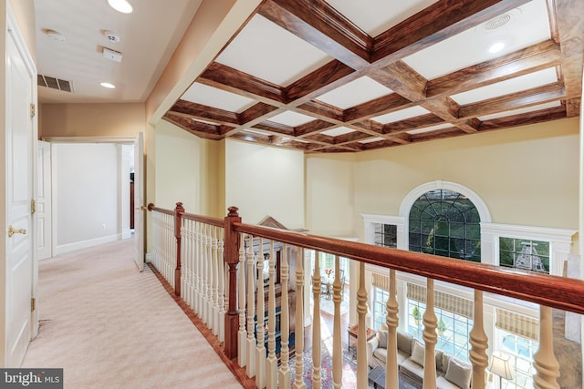 hallway featuring light colored carpet, coffered ceiling, and beam ceiling