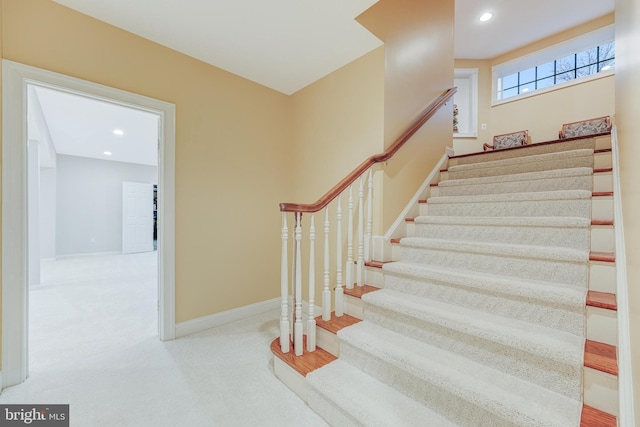 staircase featuring carpet