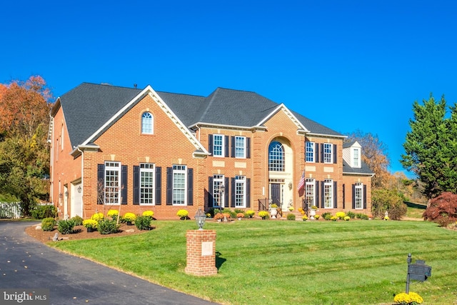 colonial home featuring a garage and a front yard