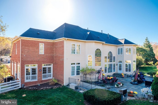 back of property featuring a yard, a patio area, and central air condition unit