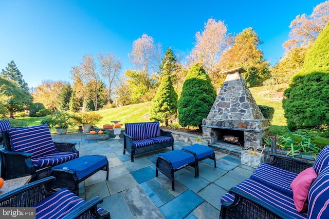 view of patio with an outdoor living space with a fireplace