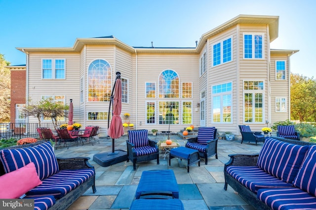 rear view of house with an outdoor living space and a patio area