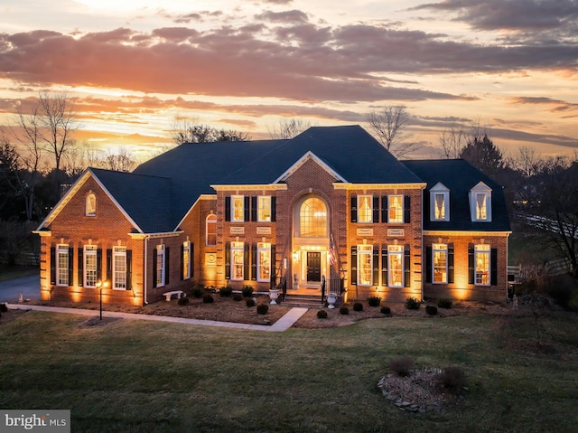 back house at dusk featuring a yard