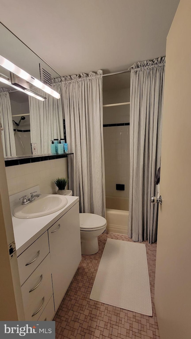 full bathroom featuring vanity, shower / bath combination with curtain, toilet, and decorative backsplash