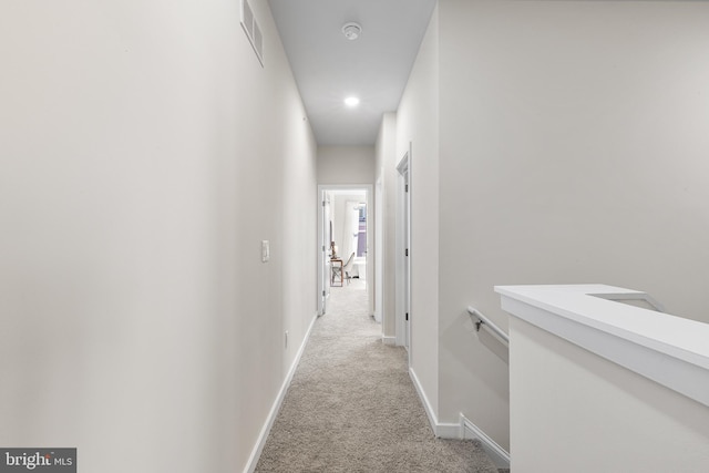 corridor featuring light colored carpet