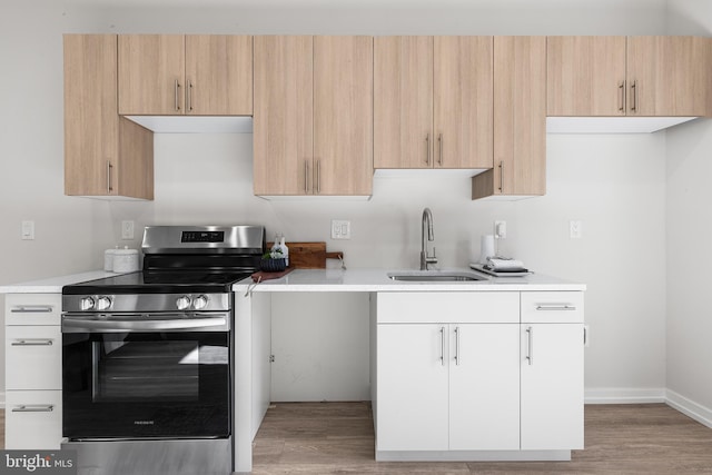 kitchen featuring light brown cabinetry, sink, white cabinetry, stainless steel range with electric stovetop, and hardwood / wood-style floors