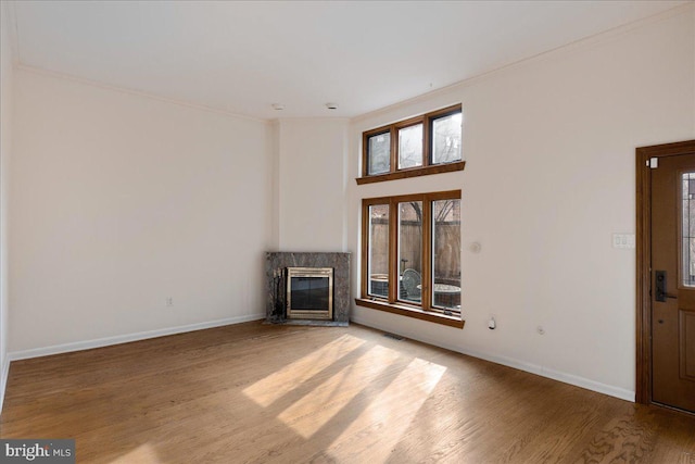 unfurnished living room featuring a fireplace and light hardwood / wood-style floors