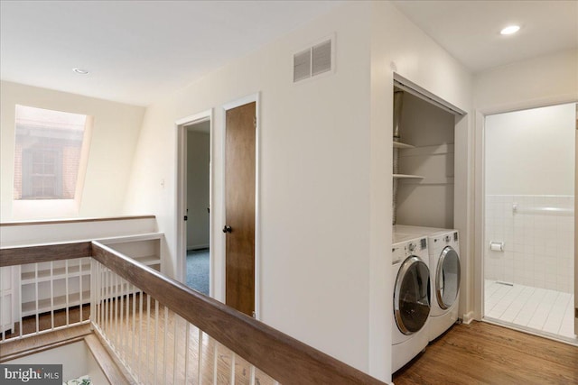 washroom with hardwood / wood-style flooring and washer and clothes dryer