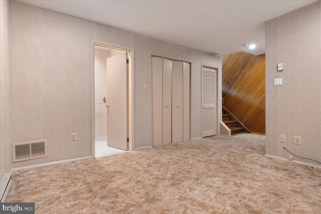 unfurnished bedroom featuring two closets and light carpet