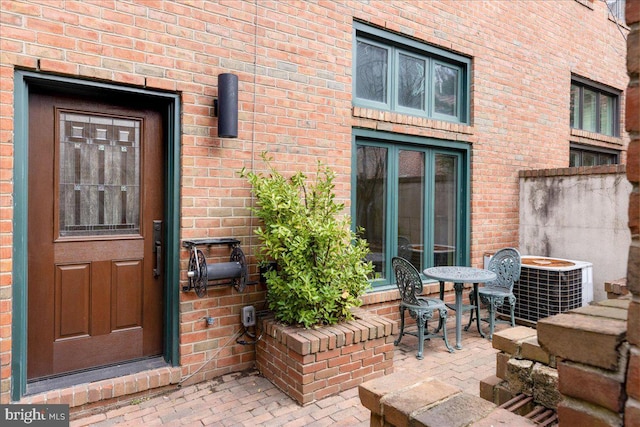 entrance to property with a patio and cooling unit