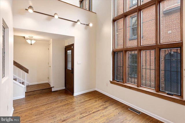 entrance foyer with hardwood / wood-style flooring and a high ceiling