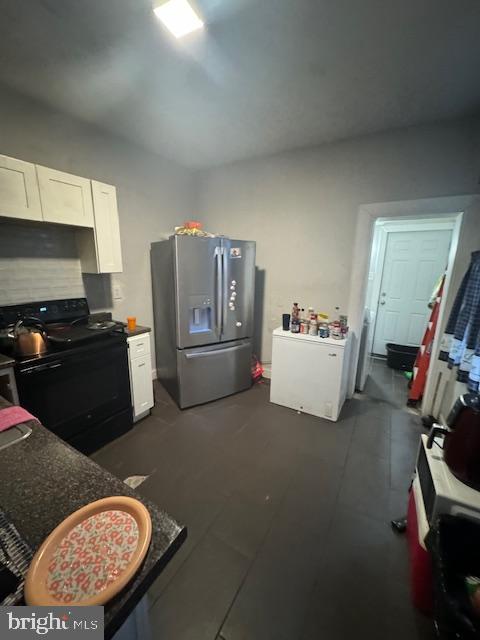 kitchen with white cabinetry, stainless steel refrigerator with ice dispenser, and black range with electric cooktop