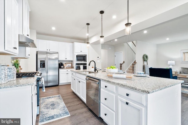 kitchen featuring under cabinet range hood, white cabinetry, a kitchen island with sink, and appliances with stainless steel finishes