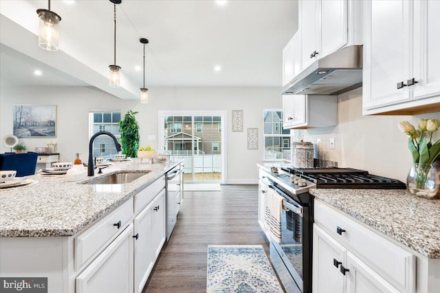 kitchen with a center island with sink, stainless steel appliances, white cabinets, a sink, and under cabinet range hood