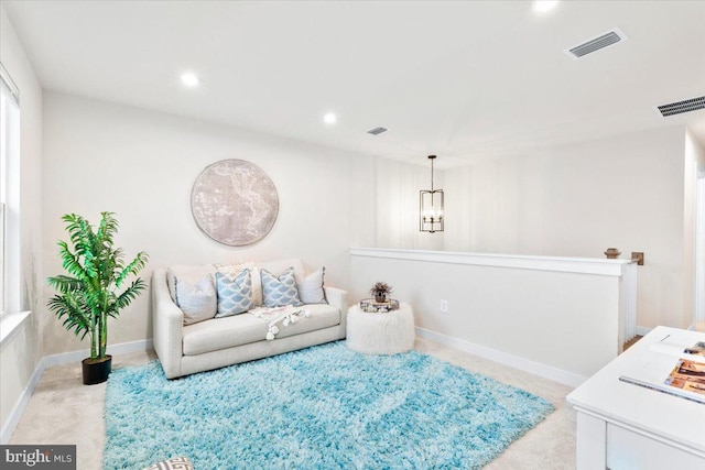 living area with recessed lighting, visible vents, and light carpet