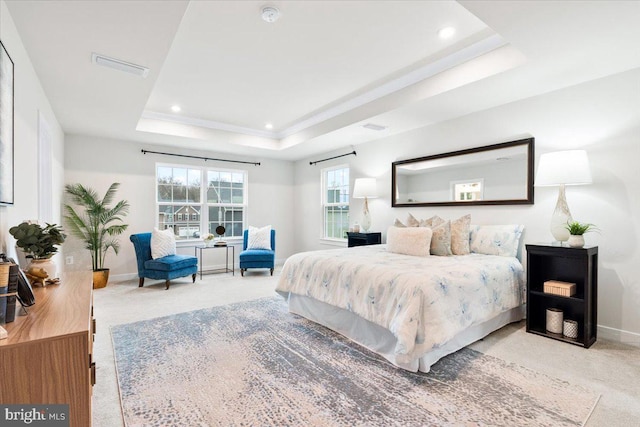 carpeted bedroom featuring a tray ceiling, visible vents, baseboards, and recessed lighting