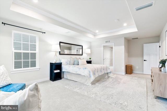 bedroom featuring a raised ceiling, visible vents, and light colored carpet