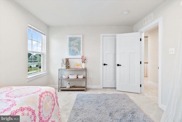 bedroom with light colored carpet, visible vents, and baseboards