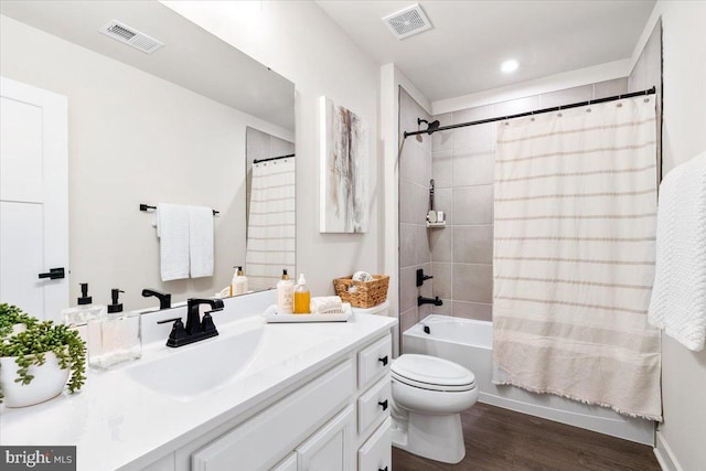 full bathroom with visible vents, toilet, shower / bath combo, vanity, and wood finished floors